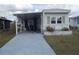 Cozy mobile home featuring a covered parking area and a well-maintained lawn at 6832 Holo Ct, North Port, FL 34287