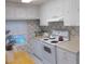 Classic kitchen with white appliances, vintage cabinets, and a cozy dining area at 6832 Holo Ct, North Port, FL 34287