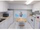 Charming kitchen with white cabinets, appliances, a small table with chairs, and plenty of sunlight at 6832 Holo Ct, North Port, FL 34287