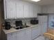 A well-lit kitchen features classic white cabinetry and appliances and a double-basin sink at 6832 Holo Ct, North Port, FL 34287