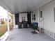 Covered patio with white siding offers a shaded outdoor area, complete with waste bins and a small seating area at 6832 Holo Ct, North Port, FL 34287