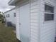 Exterior view of a white storage shed with a metal door, offering functional outdoor storage solutions at 6832 Holo Ct, North Port, FL 34287