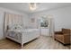 Bedroom with hardwood floors features a window with soft curtains and comfortable chair at 732 Santa Margerita Ln, Punta Gorda, FL 33950