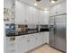 Modern kitchen with sleek stainless steel refrigerator and backsplash, white cabinets and shelving at 732 Santa Margerita Ln, Punta Gorda, FL 33950