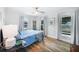 Light-filled bedroom boasts wood floors, a ceiling fan, and three large windows with bright sunlight at 809 Kings Ct, Punta Gorda, FL 33950