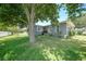 Exterior view of the home with well-kept lawn, mature trees, and charming architectural details at 809 Kings Ct, Punta Gorda, FL 33950