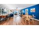 Open-concept living area features wood-look floors, a blue accent wall, and comfortable seating at 809 Kings Ct, Punta Gorda, FL 33950