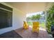 Covered patio featuring red-brick pavers, two bright yellow Adirondack chairs, and a view of the picket-fenced yard at 809 Kings Ct, Punta Gorda, FL 33950