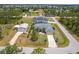 Aerial shot of a home with a pool and detached garage, surrounded by lush landscaping in a quiet neighborhood at 13297 Flaherty Ave, Port Charlotte, FL 33981