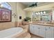 Luxury bathroom features tiled platform tub, granite countertops, and decorative plants at 13297 Flaherty Ave, Port Charlotte, FL 33981