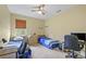 Bright bedroom with two beds, a ceiling fan, and a window overlooking the exterior at 13297 Flaherty Ave, Port Charlotte, FL 33981