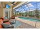 Relaxing screened-in pool area with brick pavers and comfortable seating, perfect for entertaining and enjoying the outdoors at 13297 Flaherty Ave, Port Charlotte, FL 33981