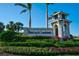 Beautifully landscaped entrance sign to Heritage Landing with lush plants and blue skies at 14267 Heritage Landing Blvd # 1223, Punta Gorda, FL 33955