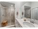 Bathroom with double sink vanity, quartz countertop, large mirrors, and glass enclosed tiled shower with bench at 14267 Heritage Landing Blvd # 1223, Punta Gorda, FL 33955