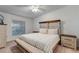 Well-lit main bedroom with a decorative wood headboard, neutral bedding, a ceiling fan, and two bedside tables at 14267 Heritage Landing Blvd # 1223, Punta Gorda, FL 33955