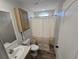 A clean bathroom featuring modern fixtures, new vinyl flooring and a stylish shower curtain at 15431 Orangeade Dr, Punta Gorda, FL 33955