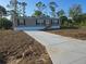 Charming home featuring a long driveway and well-manicured lawn at 15431 Orangeade Dr, Punta Gorda, FL 33955