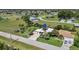 An aerial view of a single-Gathering home featuring a well-manicured lawn, palm trees, and a spacious driveway at 16232 Quesa Dr, Punta Gorda, FL 33955