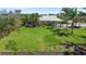Overhead view of backyard showing large manicured lawn, fenced yard, tropical landscaping and pool at 16232 Quesa Dr, Punta Gorda, FL 33955