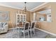 A dining room featuring a wooden table, white chairs, and a display cabinet with decorative items at 16232 Quesa Dr, Punta Gorda, FL 33955