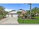 Charming home featuring a white tile roof, spacious driveway, and meticulously landscaped front yard at 16232 Quesa Dr, Punta Gorda, FL 33955