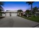 Beautiful home featuring a white tile roof, spacious driveway, and lush landscaping at dusk at 16232 Quesa Dr, Punta Gorda, FL 33955