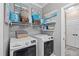 Laundry room features modern washer and dryer units with shelving and storage space at 16232 Quesa Dr, Punta Gorda, FL 33955