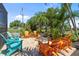 Charming outdoor patio adorned with colorful Adirondack chairs, lush tropical plants, and a cozy fire pit at 16232 Quesa Dr, Punta Gorda, FL 33955