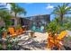 Open-air patio featuring vibrant Adirondack chairs in orange and blue, perfect for relaxing and enjoying the tropical scenery at 16232 Quesa Dr, Punta Gorda, FL 33955