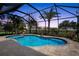 Inviting screened pool area with pavers, a palm tree and lush landscaping, creating a private oasis at 16232 Quesa Dr, Punta Gorda, FL 33955