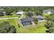 Aerial view showcasing a home with a screened pool surrounded by lush greenery in a neighborhood at 16615 Acapulco Rd, Punta Gorda, FL 33955