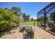 Backyard patio with seating, lush landscaping, and a screened enclosure, perfect for outdoor entertaining at 16615 Acapulco Rd, Punta Gorda, FL 33955