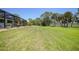 Spacious backyard featuring a well-manicured lawn, screened lanai, and mature trees for added privacy at 16615 Acapulco Rd, Punta Gorda, FL 33955