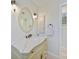Bathroom vanity features marble countertop, oval mirror and decorative sconce lighting at 16615 Acapulco Rd, Punta Gorda, FL 33955