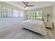 Bedroom with ceiling fan, whitewashed parquet floors and bright natural light at 16615 Acapulco Rd, Punta Gorda, FL 33955