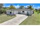 Attractive single-story home with lush landscaping, a curved driveway and an attached garage for convenience at 16615 Acapulco Rd, Punta Gorda, FL 33955