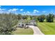 Inviting single-story home featuring a circular driveway, lush lawn and tropical trees at 16615 Acapulco Rd, Punta Gorda, FL 33955