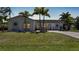 Charming home with a well-manicured lawn and tropical landscaping, including mature palm trees at 16615 Acapulco Rd, Punta Gorda, FL 33955