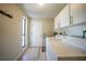 Laundry room with white cabinets and appliances, as well as a bright window at 16615 Acapulco Rd, Punta Gorda, FL 33955