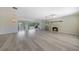 Bright open-concept living area with sleek floors that seamlessly connects to the cozy sunroom and a fireplace at 16615 Acapulco Rd, Punta Gorda, FL 33955