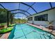 Screened pool with bright blue water, brick trim, and beautiful views of the green yard at 16615 Acapulco Rd, Punta Gorda, FL 33955