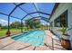 Screened-in pool area with clear blue water, brick patio, and a view of the yard at 16615 Acapulco Rd, Punta Gorda, FL 33955