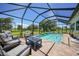 Screened pool area with outdoor seating and a view of the green backyard at 16615 Acapulco Rd, Punta Gorda, FL 33955