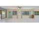 Cozy sunroom with tiled floors, ample windows offering serene outdoor views, and a ceiling fan for comfort at 16615 Acapulco Rd, Punta Gorda, FL 33955