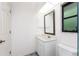 Bright bathroom featuring a stylish vanity, framed mirror, and neutral tiling at 18111 Lake Worth Blvd, Port Charlotte, FL 33948