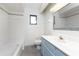 Well-lit bathroom features white tiling, blue vanity, and shower-tub combo at 18111 Lake Worth Blvd, Port Charlotte, FL 33948