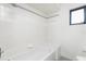 Bright bathroom features white tiled walls and shower-tub with handheld shower at 18111 Lake Worth Blvd, Port Charlotte, FL 33948