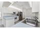 Well-lit kitchen featuring stainless appliances, white cabinetry, and tile backsplash at 18111 Lake Worth Blvd, Port Charlotte, FL 33948