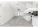 Living area with tile floors flowing into kitchen featuring stainless steel appliances and white cabinetry at 18111 Lake Worth Blvd, Port Charlotte, FL 33948