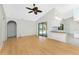 Bright living room featuring wood floors, vaulted ceiling with fan, and sliding glass doors to the pool at 18111 Lake Worth Blvd, Port Charlotte, FL 33948